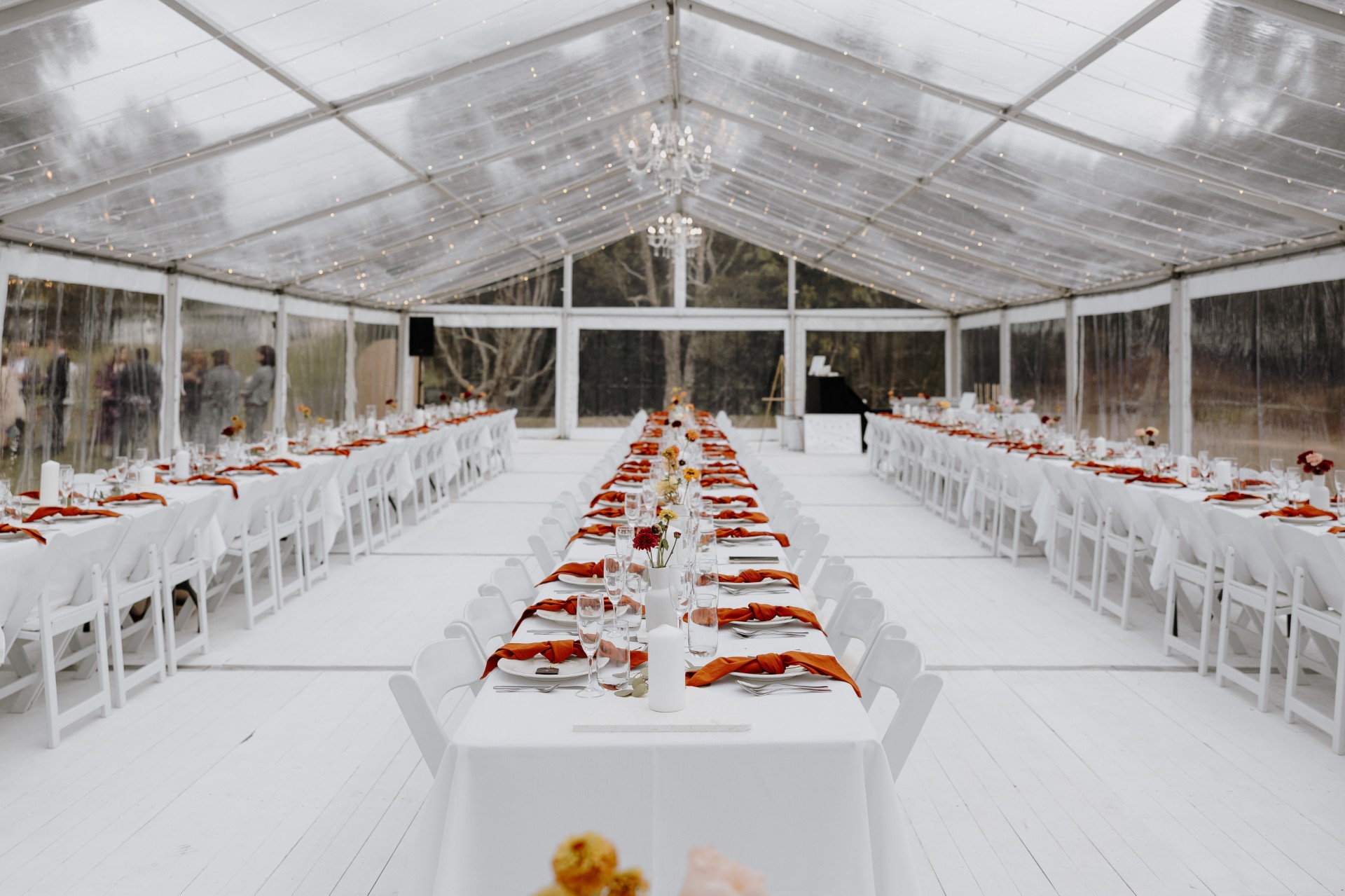 clear marquee - white timber floor - tables - white padded chairs - americana